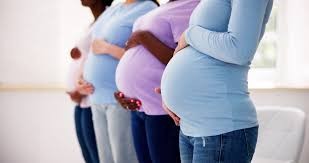 A row of four pregnant mothers